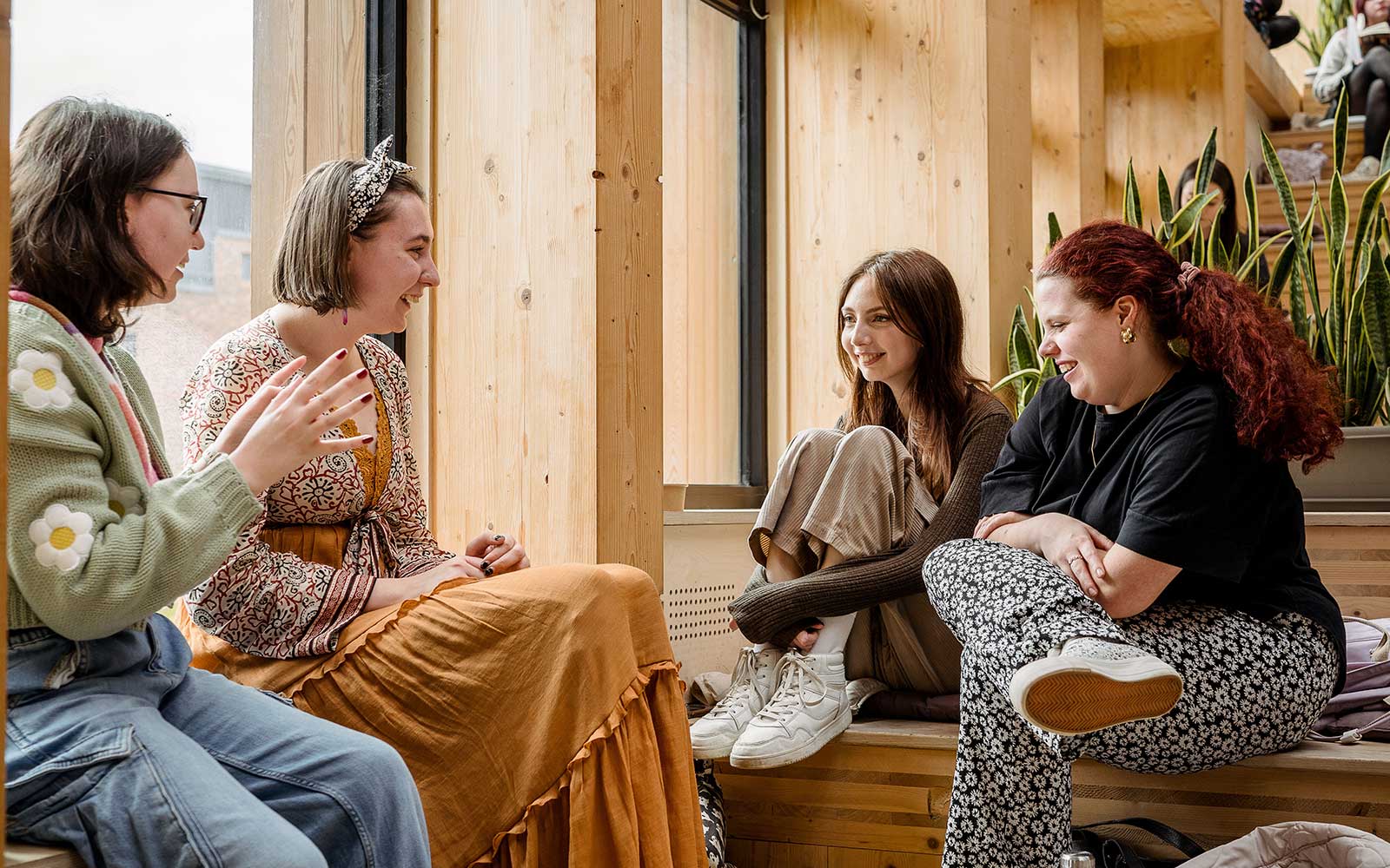Group of students sitting chatting on steps in Creative Centre atrium