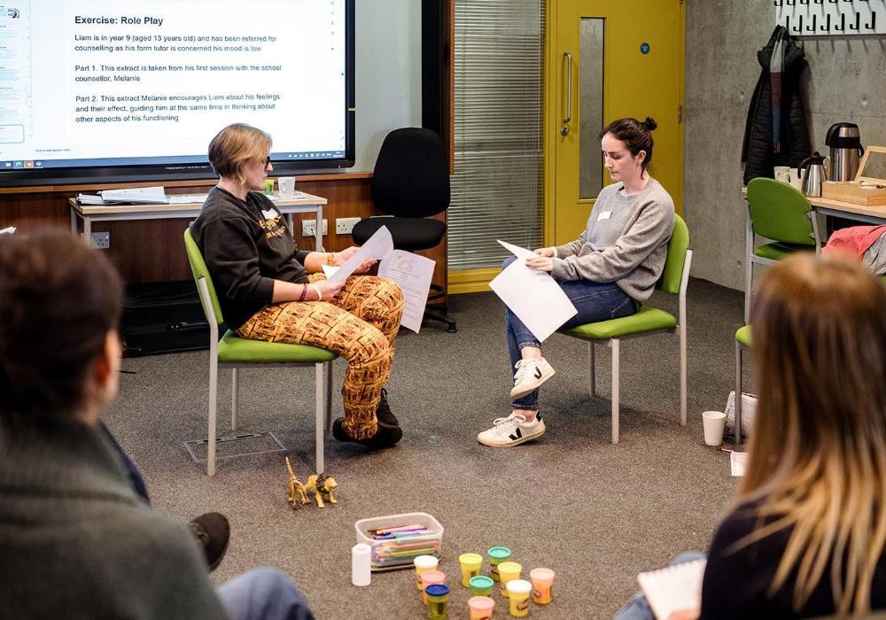 Students in chairs in circle, discussing scenario