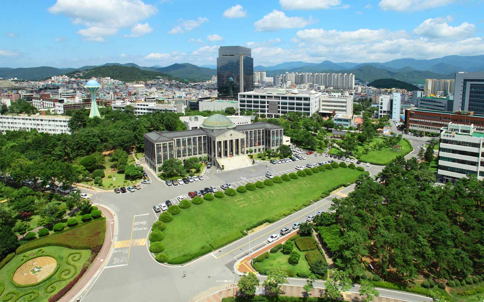 Historic building looking over lawns, with city of Daegu in the background.